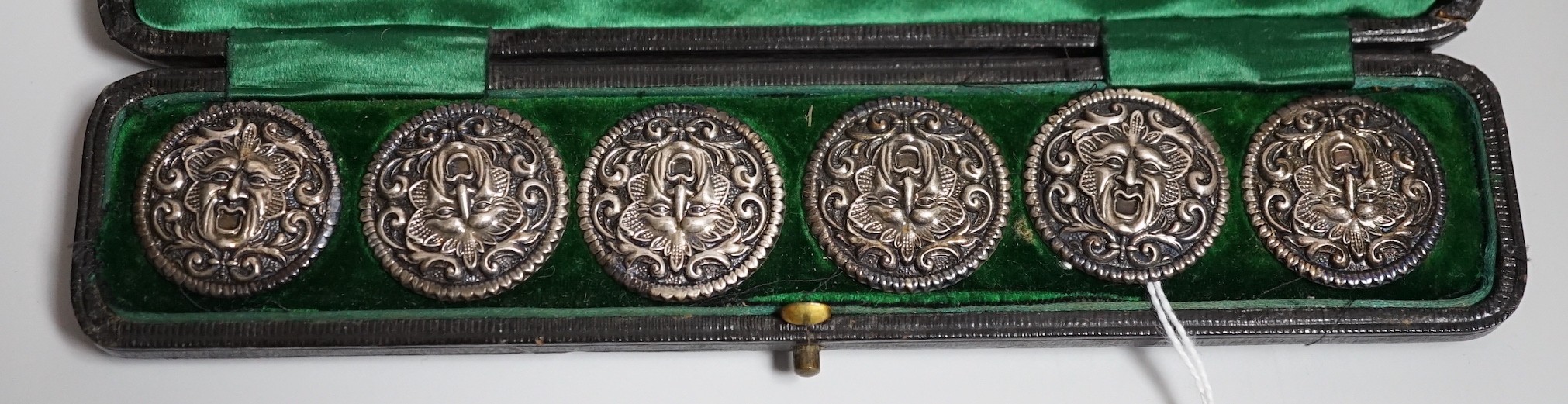 A cased set of six Edwardian silver buttons, each embossed with a mask, Henry Matthews, Birmingham, 1902, 27mm.